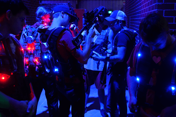 Team gears up with laser tagger and vest before combat