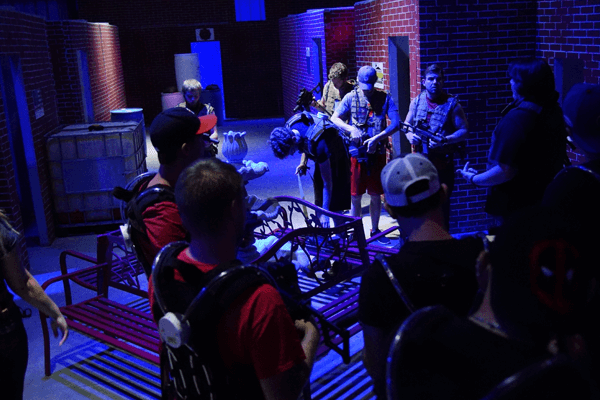 Adults and Teens strategizing on the laser tag battlefield